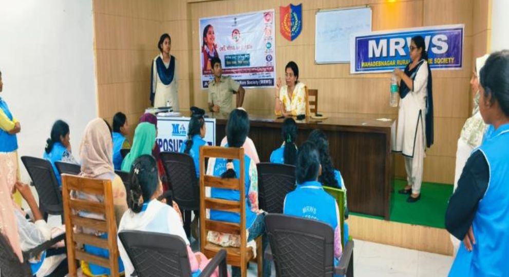 An audience seated in a seminar room listening to speakers seated at a main table during an awareness session.